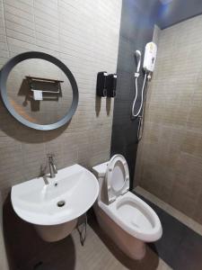 a bathroom with a sink and a toilet and a mirror at Pakarang Resort in Satun