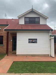 a house with a white garage door with a sign on it at Mudgee Apartments on Church Street in Mudgee