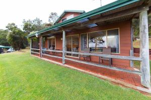 a house with a porch with benches on it at Augusta Sheoak Chalets in Augusta