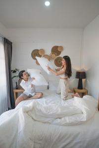 um homem e uma mulher sentados numa cama em Stay North Gate Bed and Breakfast em Chiang Mai