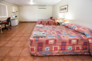 un letto grande e un divano in una stanza di Leichhardt Hotel Motel Cloncurry a Cloncurry