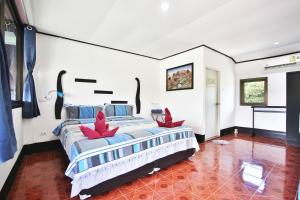 Un dormitorio con una cama con hojas rojas. en Lotus Friendly Hotel, en Chaweng