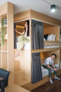 un hombre y una mujer sentados en literas en Stay North Gate Bed and Breakfast, en Chiang Mai