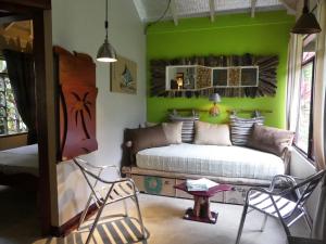 a bedroom with a bed and a green wall at Dos Casitas in Ojochal