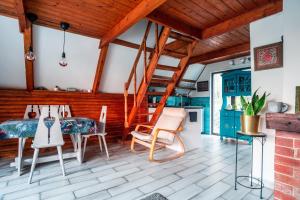a living room with a table and chairs and a staircase at kiskalács in Kismaros