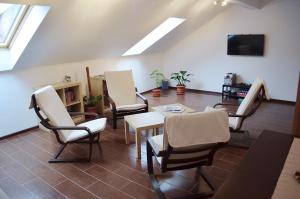 a living room with chairs and a table and a tv at Vila Andrei in Băile Olăneşti