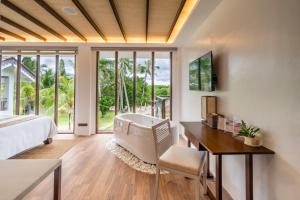 a bedroom with a bed and a desk and a tub at North Zen Villas in Panglao