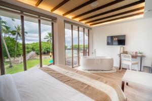 a bedroom with a large bed and a bath tub at North Zen Villas in Panglao