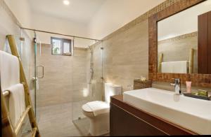a bathroom with a sink and a toilet and a mirror at North Zen Villas in Panglao Island