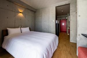um quarto com uma grande cama branca e um sofá vermelho em Hotel Little Island Okinawa Matsuyama em Naha