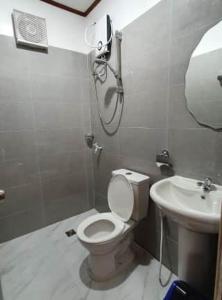 y baño con aseo y lavamanos. en AMARAV Pension House Nacpan El Nido en El Nido