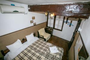 niewielka sypialnia z łóżkiem i krzesłem w obiekcie The Tinkov house in Lovech w mieście Łowecz