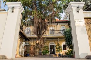 una vecchia casa con un albero di fronte di La Villa a Battambang