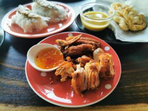 two red plates of food with chicken and dipping sauce at Pakarang Resort in Satun