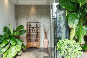 una habitación con plantas y una estantería de medicamentos en S 2 Modern Boutique Hotel en Vientián