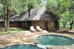 a house with a pool in front of it at Sable Creek Safari Lodge in Tzaneen