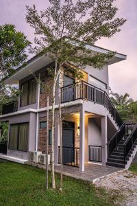 Casa con balcón y árbol en Sementra Hot Spring Nature Resort en Gopeng