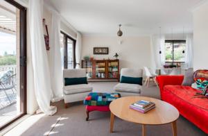 a living room with a red couch and a table at Casa de Piña walk to the beach in Newport