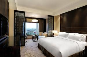 a bedroom with a large bed and a large window at Crowne Plaza New Delhi Mayur Vihar Noida, an IHG Hotel in New Delhi