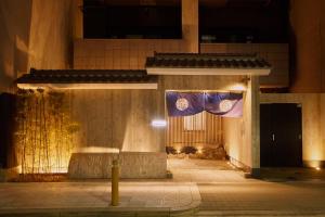 a building with a flag hanging from it at night at Hotel Amaterrace Nippombashi-higashi in Osaka