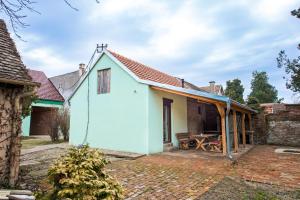 une maison blanche avec un toit rouge et une terrasse dans l'établissement PB Garden Apartman, à Sremska Mitrovica