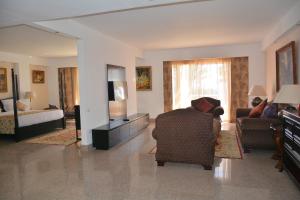 - un salon avec un canapé, une chaise et une télévision dans l'établissement Royal Monte-Carlo Sharm Resort & SPA, à Charm el-Cheikh