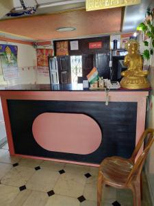 einen Tresen in einem Restaurant mit einem Stuhl daneben in der Unterkunft HOTEL BUDDHA in Kushinagar