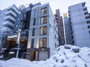 un edificio con la neve davanti di UCHI Susukino 5.7 a Sapporo