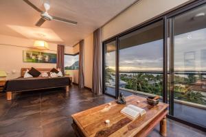 a living room with a couch and large windows at Happy Days Guest House in Le Morne