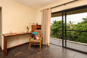 a home office with a desk and a large window at Happy Days Guest House in Le Morne