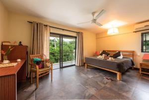 a bedroom with a bed and a large window at Happy Days Guest House in Le Morne