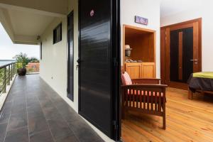 a room with a black door and a balcony at Happy Days Guest House in Le Morne