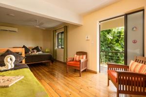 a bedroom with a bed and a living room at Happy Days Guest House in Le Morne