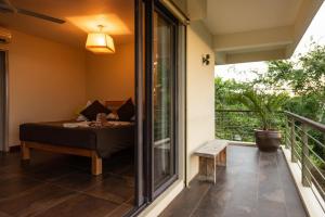 a room with a bed and a balcony at Happy Days Guest House in Le Morne