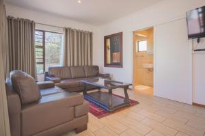 a living room with a couch and a table at President Lodge in Edenvale