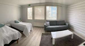 a living room with a couch and a bed at Gasthaus Kantolankulma in Lappeenranta
