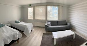 - un salon avec un canapé et un lit dans l'établissement Gasthaus Kantolankulma, à Lappeenranta
