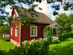 una casa roja con un banco delante en Trakt Forest Hotel, en Holsbybrunn