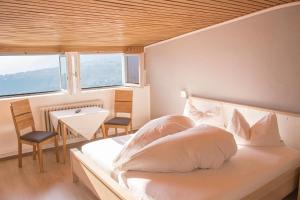 シェーナにあるSchenna Garni Eden Bed & Breakfastのベッドルーム1室(白いシーツ付きのベッド1台、窓付)