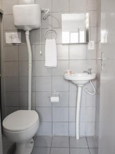 a bathroom with a toilet and a sink at Pousada Atlantico Centro - Fortaleza in Fortaleza