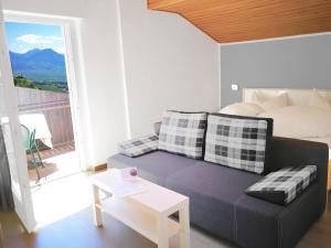a bedroom with a large bed and a large window at Schenna Garni Eden Bed & Breakfast in Schenna