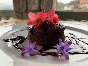 a chocolate cake with flowers on a white plate at Skadar Lake Family Resort in Rijeka Crnojevića