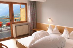 a hotel room with two beds and a window at Schenna Garni Eden Bed & Breakfast in Schenna