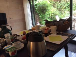 Zottegem的住宿－Poortbossen，一张桌子,配有茶壶和一些食物