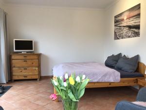 a bedroom with a bed and a vase of flowers at Ferienwohnungen Camping SPO OHG in Sankt Peter-Ording