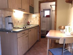 a small kitchen with a sink and a table at Ferienwohnungen Camping SPO OHG in Sankt Peter-Ording