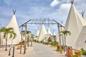 The ANMON Resort Bintan في لاغوي: شارع فيه خيام بيضاء ونخل