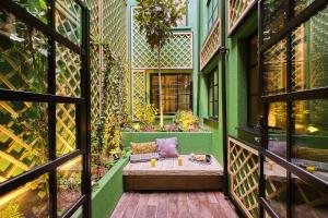 - un balcon avec un canapé dans un bâtiment vert dans l'établissement The Gyle, à Londres