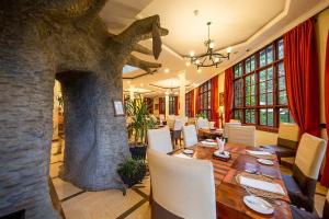 a dining room with a table and a stone fireplace at African Tulip in Arusha