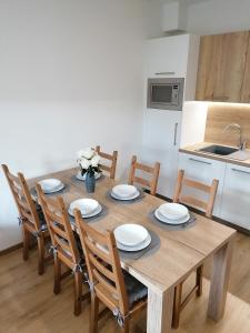 einen Esstisch mit Stühlen und eine Küche in der Unterkunft Apartmán Frymburk-Lipno G10 in Frymburk